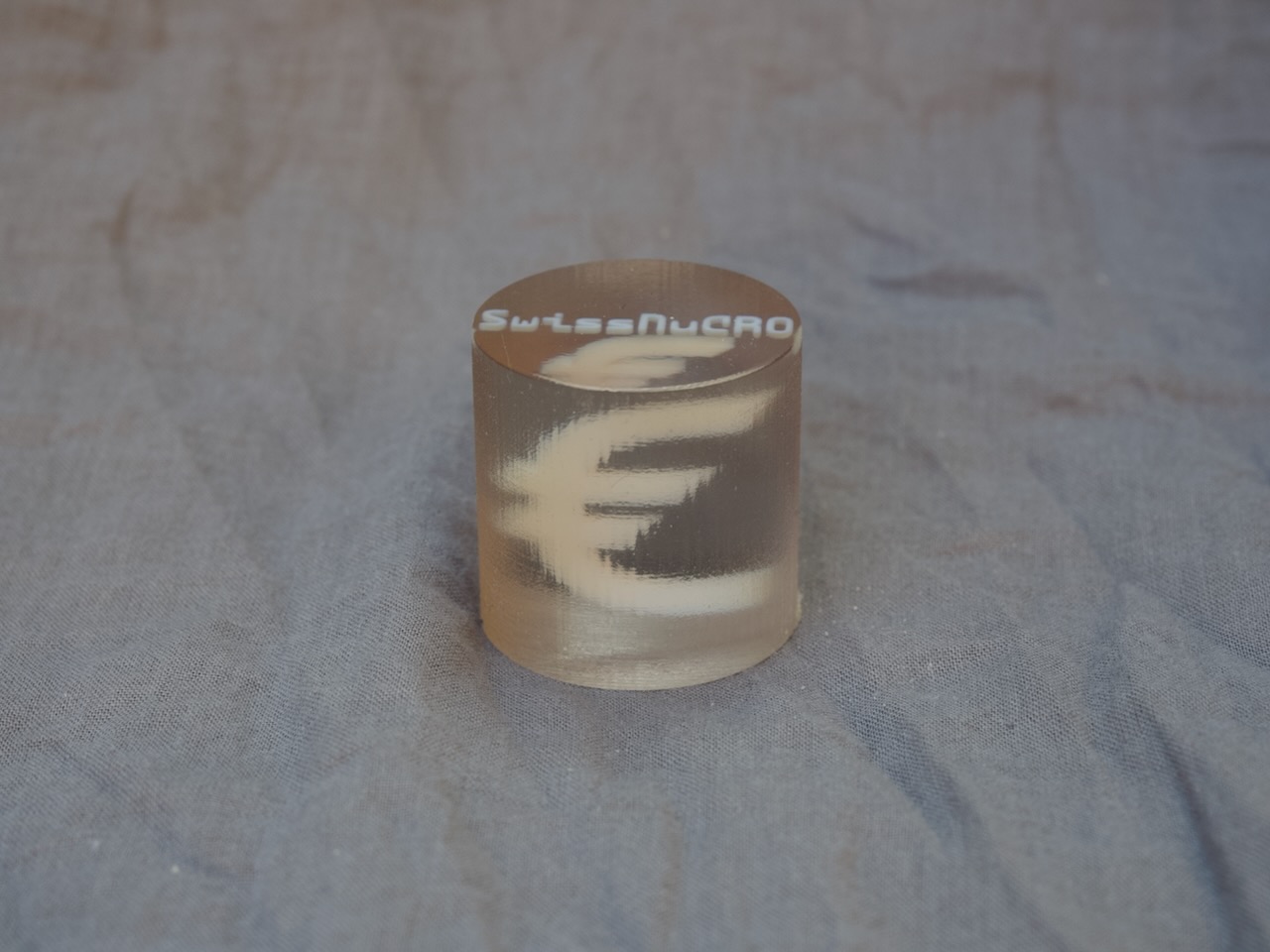 A symbol-shaped internal structure within a cylindrical body.